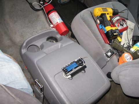 1995 Ford Bronco - The interior of a vehicle is shown with various tools and a fire extinguisher, along with an aftermarket stereo system.