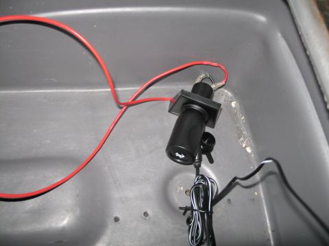 1995 Ford Bronco - Close-up of car stereo wiring, showing red and black cables connected to a component within a gray compartment.