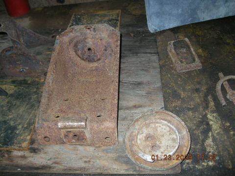 1997 Ford F-250 - Several heavily rusted metal components are laid out on a weathered wooden surface.