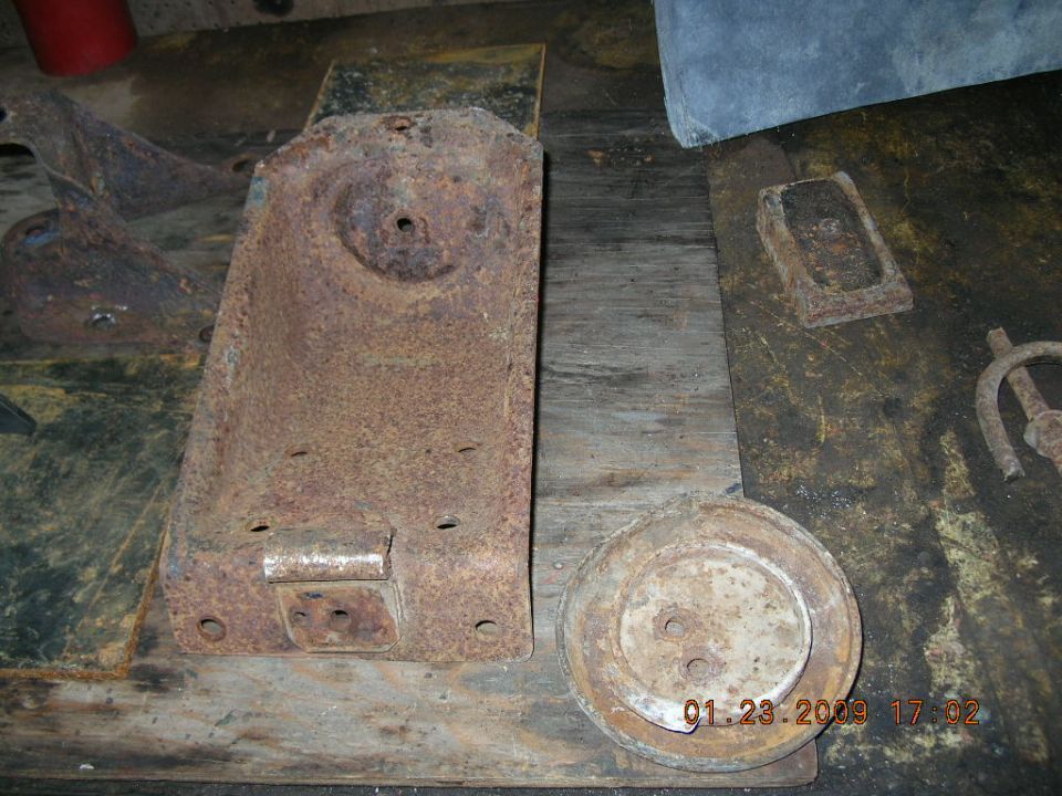 Rusted metal bracket and circular plate on a wooden surface