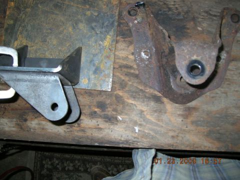 1997 Ford F-250 - New and old metal brackets sit on a workbench next to each other.