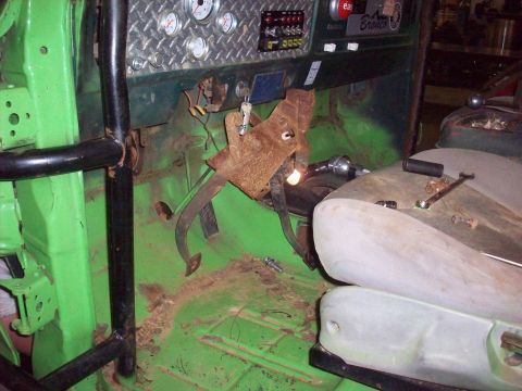 1978 Ford Bronco - The interior of a vehicle shows a roll cage, gauges on the dashboard, and rusty pedals.