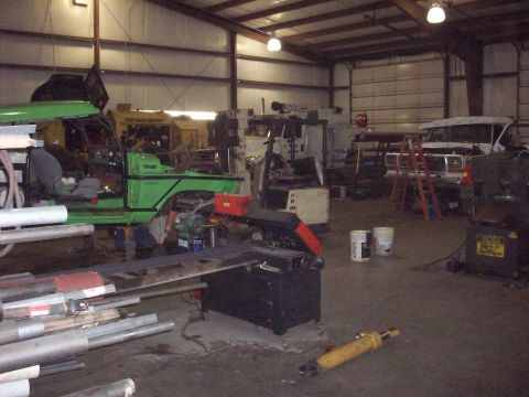 1978 Ford Bronco - A green SUV, possibly from the early 1980s, is undergoing modifications in a cluttered garage.