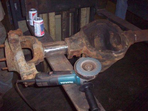 1978 Ford Bronco - Working on a differential housing with an angle grinder. Two cans of beer are nearby.