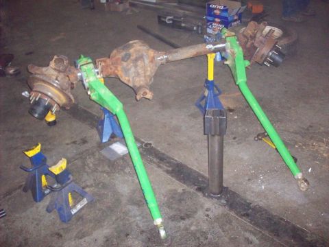 1978 Ford Bronco - A modified rear axle assembly, likely for an off-road vehicle, is supported by jack stands in a workshop.