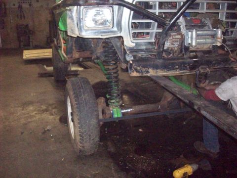 1978 Ford Bronco - Front view of a 1978 Ford Bronco undergoing modifications in a workshop, showing its suspension and grille.