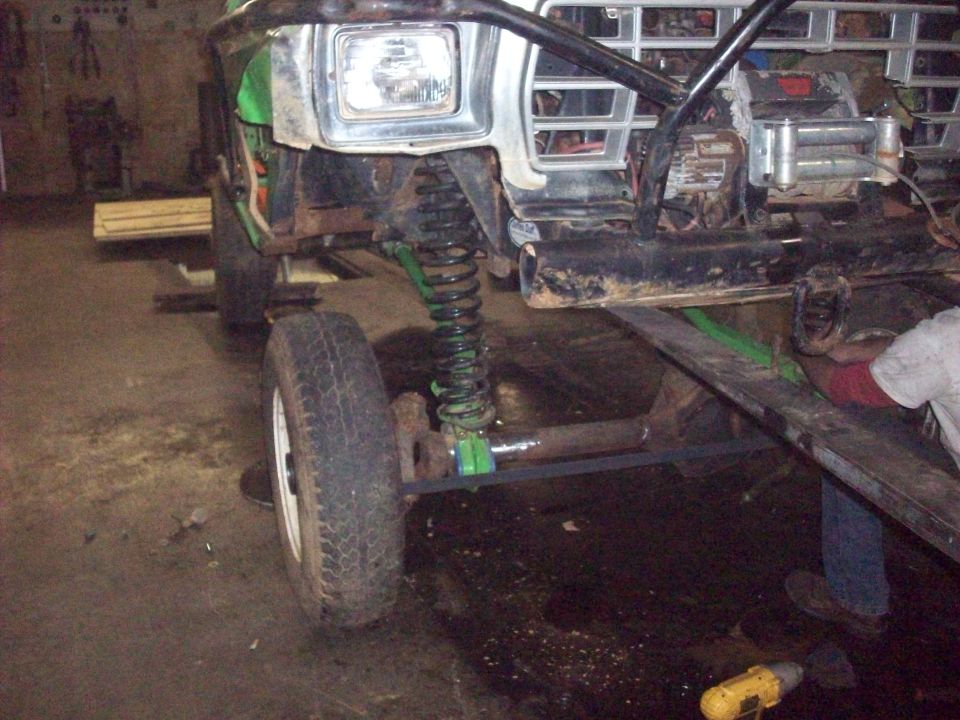 1978 Ford Bronco front suspension and grille, green paint, off-road modifications, in a workshop