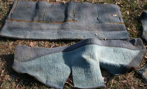 1991 Ford C-350 (Centurion Conversions) - Two pieces of worn blue carpet are laid out on the ground, showing signs of age and use.