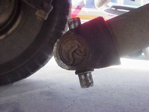 1989 Ford Bronco - A close-up view of a vehicle's suspension joint, showing mechanical components and a circular emblem. The registry claims it is a 1989 Ford…