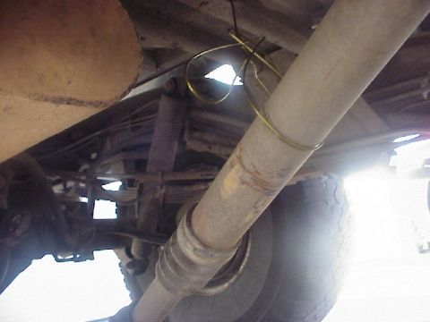 1989 Ford Bronco - Underbody view of a rear driveshaft with its slip yoke and U-joint, marked with a yellow index/phasing line and wrapped with yellow wire fo…