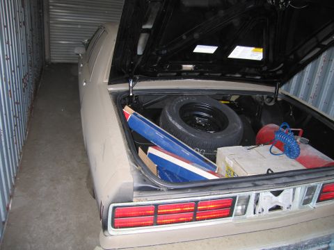 1991 Ford LTD Crown Victoria - Photograph of an open vehicle trunk containing a spare tire and parts in storage, not a technical document.