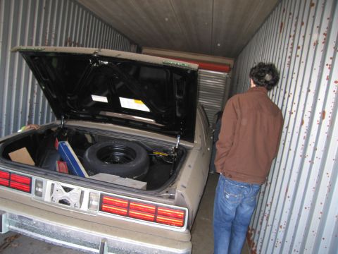 1991 Ford LTD Crown Victoria - Photograph of a person at the open trunk of a stored sedan, not a technical document.