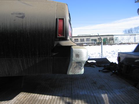 1991 Ford LTD Crown Victoria - Photograph of the dusty rear corner and taillight of a Chevrolet Caprice on a flatbed tow truck.