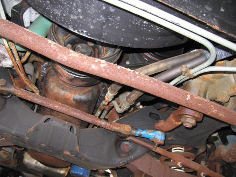 1991 Ford LTD Crown Victoria - Photograph of the underside of a vehicle showing corroded exhaust, sway bar and suspension components.