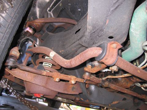 1991 Ford LTD Crown Victoria - Photograph of the front undercarriage of a vehicle with heavily rusted suspension and steering parts.