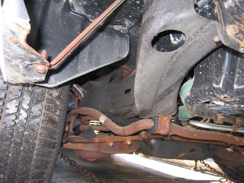 1991 Ford LTD Crown Victoria - Photograph of the rear undercarriage of a vehicle showing the tank, frame and rusted suspension components.