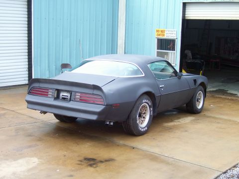 1978 Pontiac Trans Am - Rear view of a matte black 1978 Pontiac Trans Am, possibly undergoing restoration.