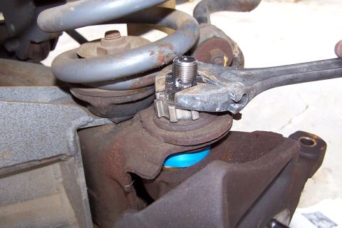 1990 Ford Bronco - A wrench is used to adjust the nut on a vehicle's ball joint during a repair.