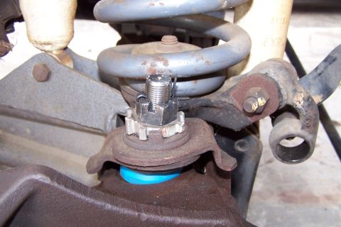 1990 Ford Bronco - Close-up view of a vehicle's suspension system, focusing on the ball joint assembly.
