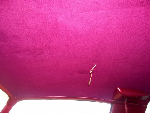 1978 Pontiac Trans Am - The interior of a car shows a pink headliner with a dangling wire, suggesting custom work or a repair in progress.