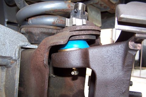 1990 Ford Bronco - Ball joint assembly with blue boot and zerk fitting, part of a vehicle's suspension system.