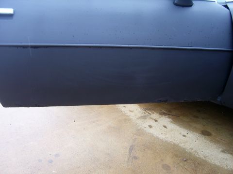 1978 Pontiac Trans Am - The lower section of a car's door and body panel shows signs of wear and tear, with visible scuffs and rust near the bottom edge.