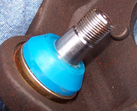 1990 Ford Bronco - Close-up of a vehicle's ball joint, showing the blue protective boot and metal stud.