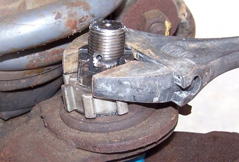 1990 Ford Bronco - A wrench is used to tighten a ball joint nut on a vehicle's suspension system.