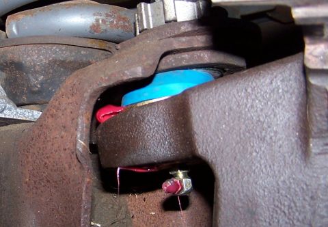 1990 Ford Bronco - This is a close-up view of a vehicle's ball joint assembly, showing its various components and lubrication.