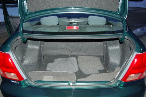 2001 Toyota Echo - The interior of a green sedan's trunk is shown with four grey floor mats.