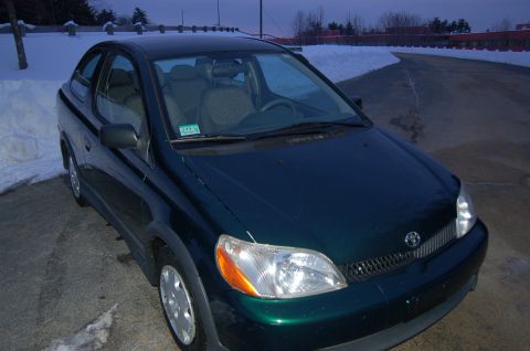 2001 Toyota Echo - A dark green 2001 Toyota Echo is parked outdoors in a snowy environment, viewed from the front three-quarter angle.