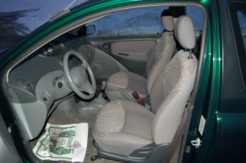 2001 Toyota Echo - Interior view of a green car, showing the front seats and dashboard. Text visible on floor mat.