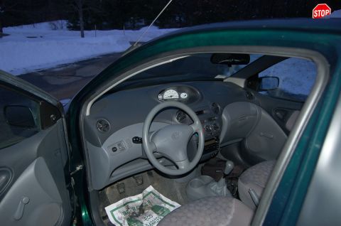 2001 Toyota Echo - The interior of a car is shown with the driver's side door open, revealing the dashboard and seats.