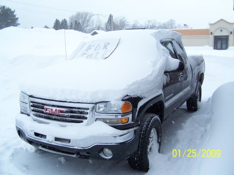1900 Acura CL - A GMC pickup truck is heavily covered in snow, with a 'For Sale' sign visible on the windshield.