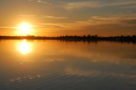 1985 Ford Ranger - A sunset casts a warm glow over a tranquil lake, reflecting the vibrant colors of the sky.