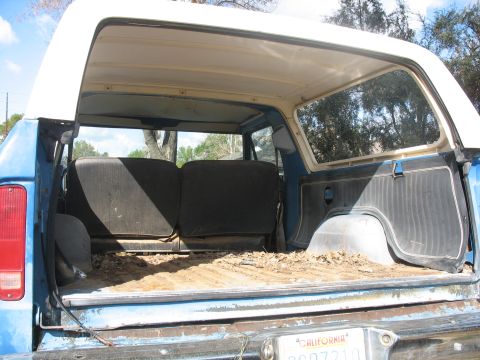 1987 Ford Bronco - Rear interior view of a 1987 Ford Bronco, showing the cargo area and folded seats.