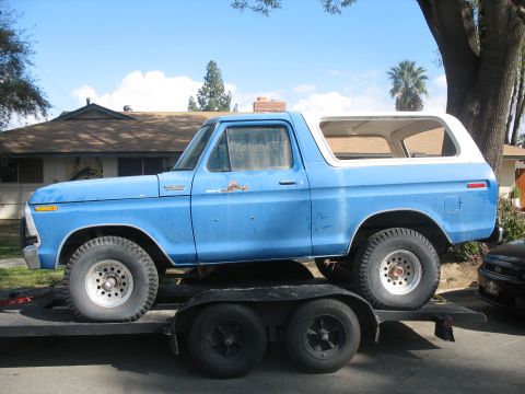 1987 Ford Bronco - A blue Ford Bronco is loaded onto a trailer, ready for transport.