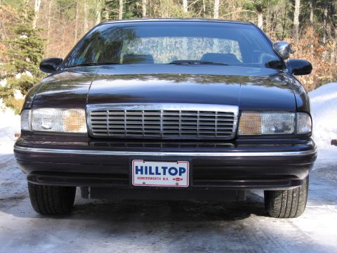 1991 Ford LTD Crown Victoria - Front view of a dark sedan with a prominent chrome grille and clear headlights.