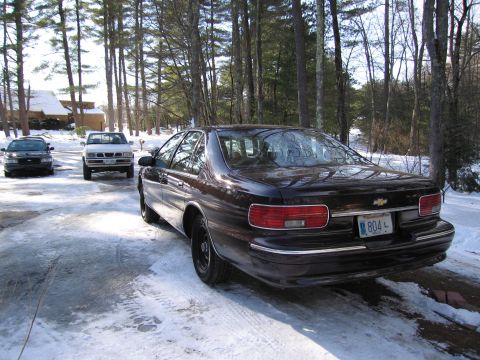 1991 Ford LTD Crown Victoria - A dark sedan with a Massachusetts license plate is parked on a snowy driveway.