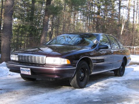 1991 Ford LTD Crown Victoria - This dark sedan, likely a 1994 model, is seen from a three-quarter front view on a snowy day.