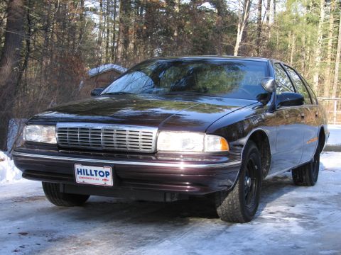 1991 Ford LTD Crown Victoria - Dark sedan with chrome grille and 'HILLTOP' plate parked in snowy conditions.