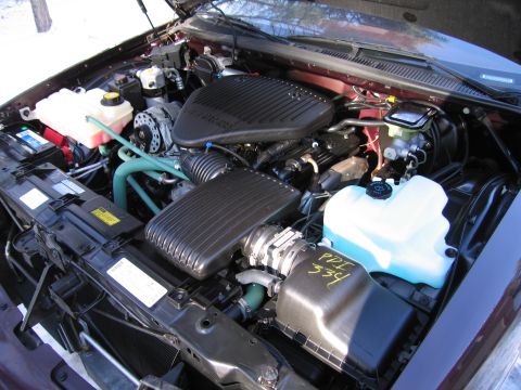 1991 Ford LTD Crown Victoria - The engine compartment of a vehicle is shown with various components and fluid tanks visible.