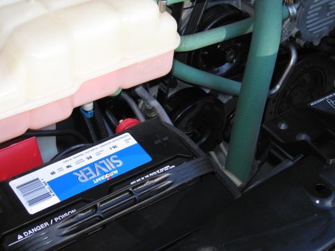 1991 Ford LTD Crown Victoria - Close-up view of a vehicle's engine bay, showing the coolant reservoir and a prominent Autocraft Silver battery.
