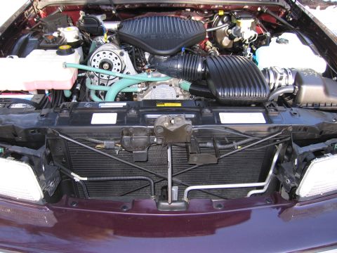 1991 Ford LTD Crown Victoria - Engine bay of a maroon vehicle, showing the V8 engine and associated components.