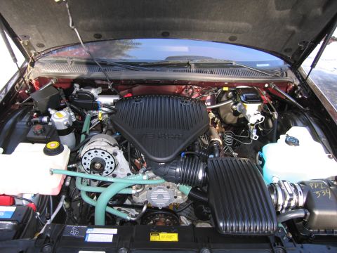 1991 Ford LTD Crown Victoria - The engine bay of a vehicle, a prominent black air intake system and various hoses.