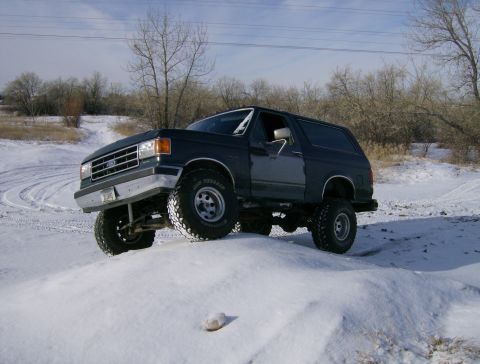 1990 Ford Bronco - This 1990 Ford Bronco is shown navigating a snowy terrain with one front wheel lifted.