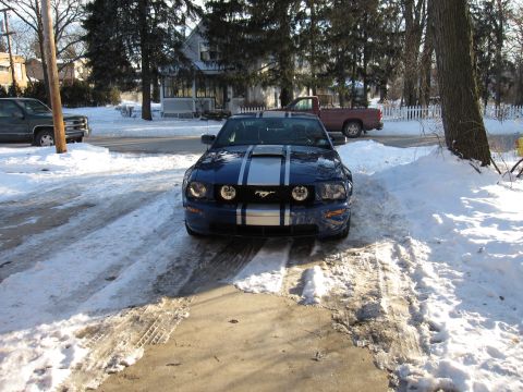 1992 Ford Bronco - Front view of a blue Ford Mustang with silver racing stripes in a snowy driveway.