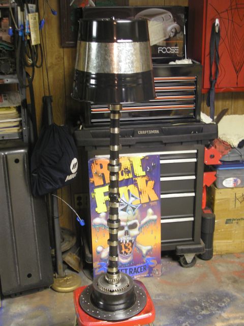 1995 Ford Bronco - A lamp constructed from automotive parts, including a camshaft and brake rotor, stands in a garage.