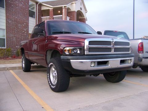 2001 Dodge 1500 - Maroon pickup truck parked in a lot, showing its front end and side profile.