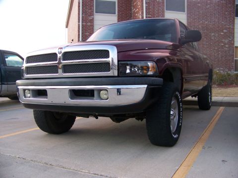 2001 Dodge 1500 - This maroon 2001 Dodge 1500 pickup truck is shown from a 3q-front angle, with readable text visible on the tire.